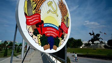 In this file photo taken on September 11, 2021 a woman walks past a huge coat of arms of Transnistria - Moldova's pro-Russian breakaway region on the eastern border with Ukraine, in Transnistria's capital of Tiraspol. (AFP)