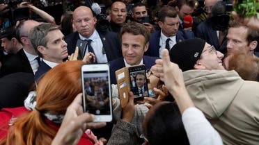 French President Emmanuel Macron shakes hands with residents and vendors at the Saint-Christophe market square in Cergy, Paris suburb, during his first trip after being re-elected president, France, April 27, 2022. REUTERS/Benoit Tessier/Pool