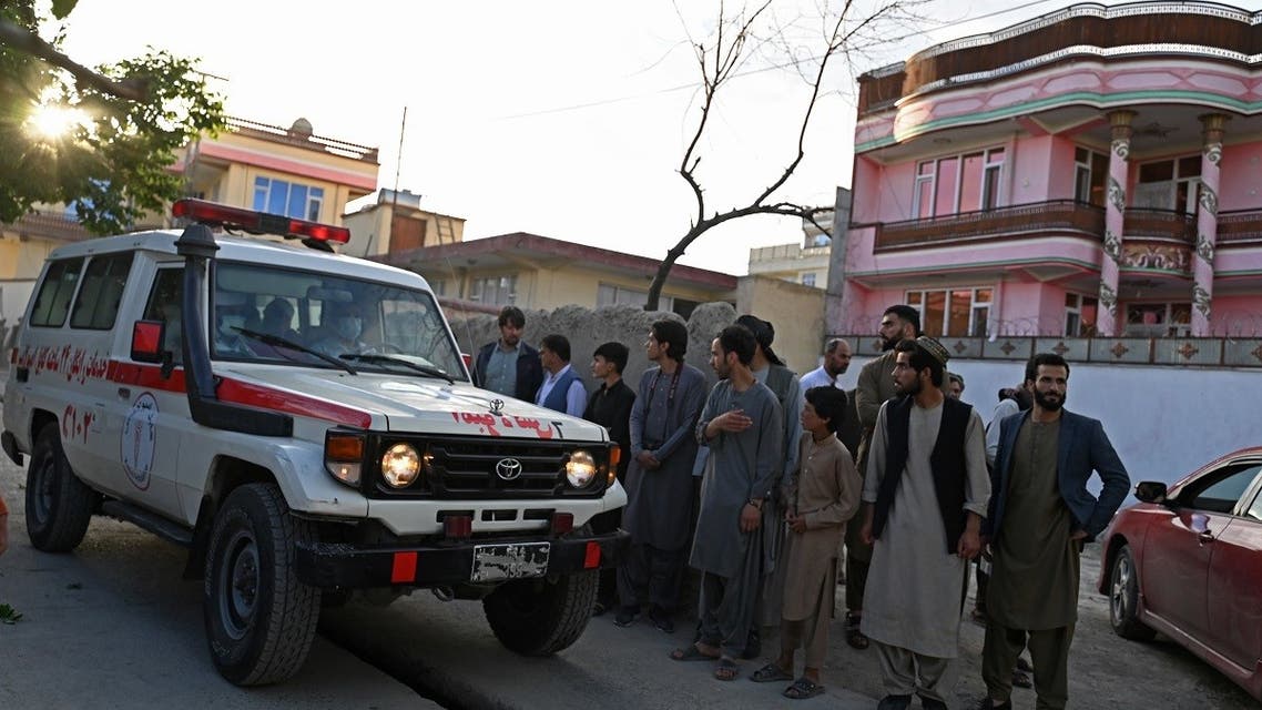 Onlookers stand next to an ambulance carrying victims near the site of a blast in Kabul on April 29, 2022. (AFP)