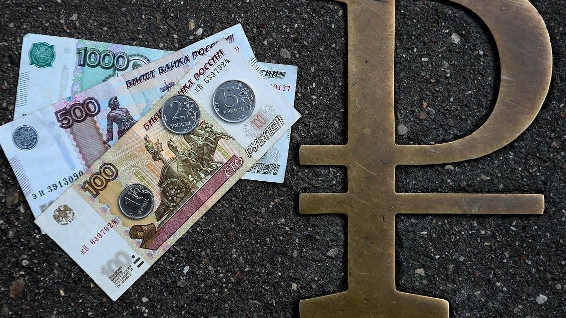 This picture taken on August 13, 2021, in Moscow, shows Russian ruble coins and banknotes pictured next to Russian ruble sign. (AFP)