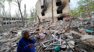 Local resident and nursery teacher Natalya Kalugina, 64, stands in a courtyard near a block of flats, which was destroyed during Ukraine-Russia conflict in the southern port city of Mariupol, Ukraine April 29, 2022. (Reuters)