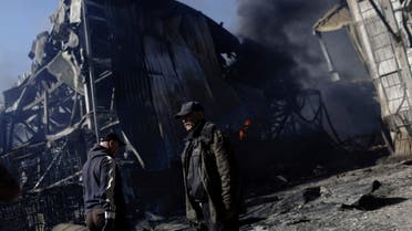 People walk at a damaged area inside a burning plant, following Russian shelling amid Russia's attack on Ukraine, in Kharkiv, Ukraine, April 30, 2022. (Reuters)