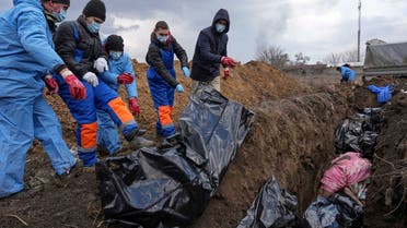 FILE - Dead bodies are placed into a mass grave on the outskirts of Mariupol, Ukraine, Wednesday, March 9, 2022 as people cannot bury their dead because of the heavy shelling by Russian forces. (AP Photo/Evgeniy Maloletka, File)