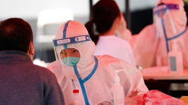 Medical workers in protective suits collect swabs from residents at a makeshift nucleic acid testing site during a mass testing for the coronavirus disease (COVID-19) in Haidian district of Beijing, China May 2, 2022. REUTERS/Carlos Garcia Rawlins