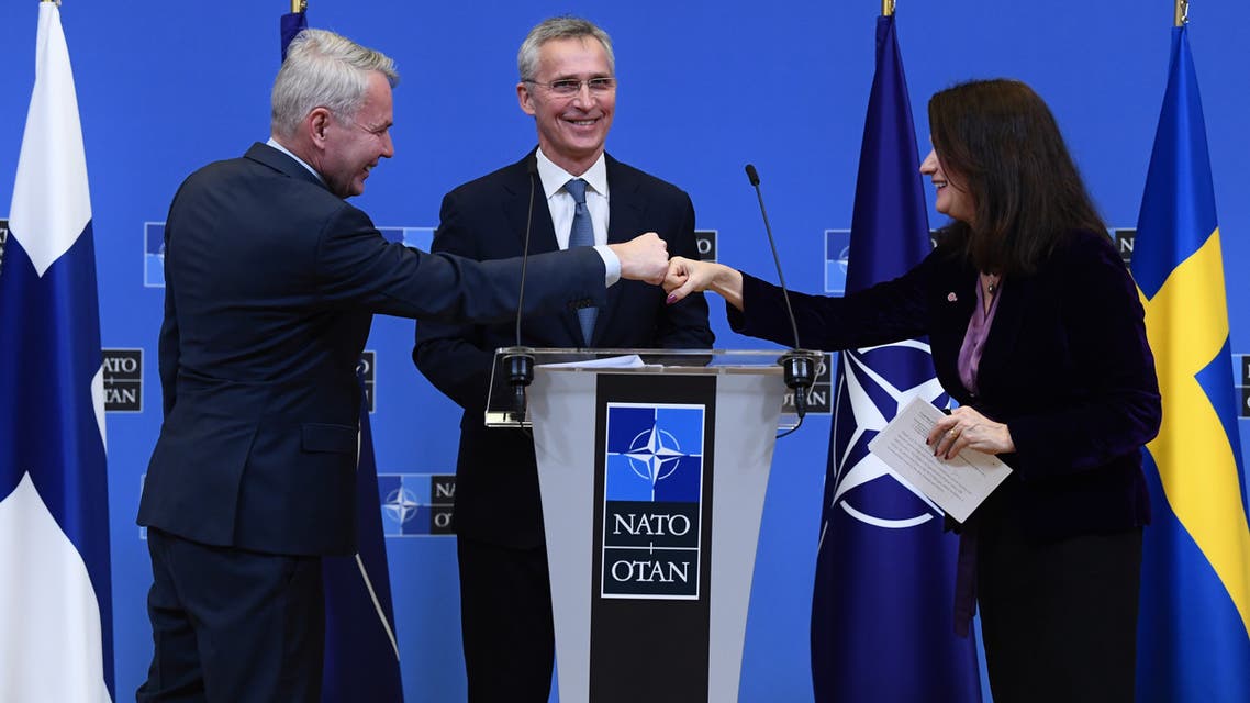 NATO Secretary General Jens Stoltenberg (C) looks on as Finland Ministers for Foreign Affairs Pekka Haavisto (L) and Sweden Foreign minister Ann Linde (R) bump fists after holding a joint press conference after their meeting at the Nato headquarters in Brussels on January 24, 2022. (Photo by JOHN THYS / AFP)
