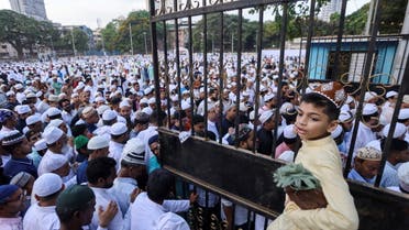 A boy holding a prayer mat waits to leave a football ground after Eid al-Fitr prayers, marking the end of the holy fasting month of Ramadan, in Mumbai, India May 3, 2022. (Reuters)