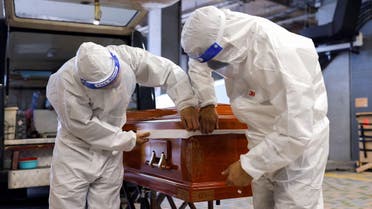 Funeral workers wear personal protective equipment (PPE) as they seal up a coffin of coronavirus disease (COVID-19) victim before cremation, in Hong Kong, China, April 1, 2022. (File photo: Reuters)