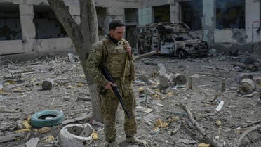 A Ukranien soldier stands outside a school hit by Russian rockets in the southern Ukraine village of Zelenyi Hai between Kherson and Mykolaiv, less than 5km from the front line on April 1, 2022. (AFP)