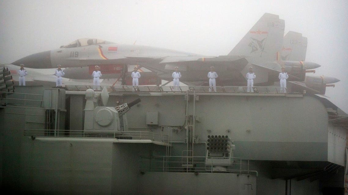 Sailors stand near fighter jets on the deck of the Chinese People’s Liberation Army (PLA) Navy aircraft carrier Liaoning as it participates in a naval parade to commemorate the 70th anniversary of the founding of China’s PLA Navy in the sea near Qingdao, in eastern China’s Shandong province on April 23, 2019. (AFP)