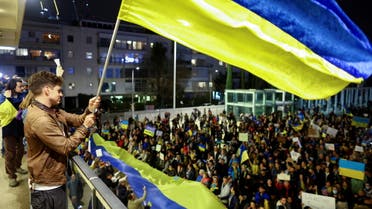 A man waves a flag from a balcony in front of demonstrators attending a rally in support of Ukraine, after Russia launched a massive military operation against Ukraine, in Tel Aviv, Israel, February 26, 2022. (File photo: Reuters)