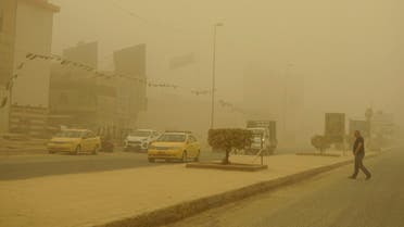 A man crosses a main road during a Spring sandstorm in the Iraqi capital Baghdad on May 5, 2022. Iraq is yet again covered in a thick sheet of orange as it suffers the latest in a series of dust storms that have become increasingly common. Iraq was hammered by a series of such storms in April, grounding flights and leaving dozens hospitalised with respiratory problems. (AFP)