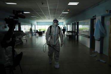 A health worker, wearing protective suit and face mask, walks as he prepares to disinfect a hallway of a hospital after a case of Ebola was confirmed in Abidjan, Ivory Coast August 16, 2021. REUTERS/Luc Gnago