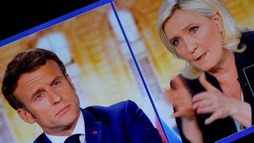 A picture of a tv screen shows the French presidential election debate between French President Emmanuel Macron, candidate for his re-election, and French far-right National Rally (Rassemblement National) party candidate Marine Le Pen, in Paris, France, April 20, 2022. REUTERS/Christian Hartmann