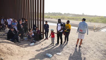 Migrants from Haiti, seeking asylum in the US, join others waiting next to the border wall separating the US and Mexico, as they wait to be processed near Yuma, Arizona, US, April 30, 2022. Picture taken April 30, 2022. (File photo: Reuters)