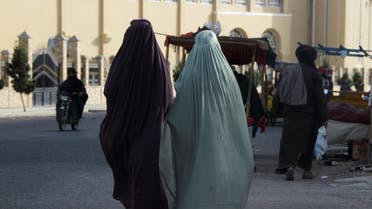 Burqa-clad women walk along a street in Kandahar on May 7, 2022. (AFP)