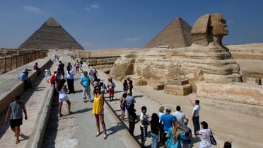 Tourists take pictures at the Sphinx and the Pyramids of Giza in Cairo. (Reuters) 
