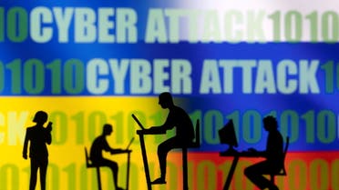 Figurines with computers and smartphones are seen in front of the words Cyber Attack, binary codes, and Russian and Ukrainian flags, in this illustration taken February 15, 2022. (Reuters)