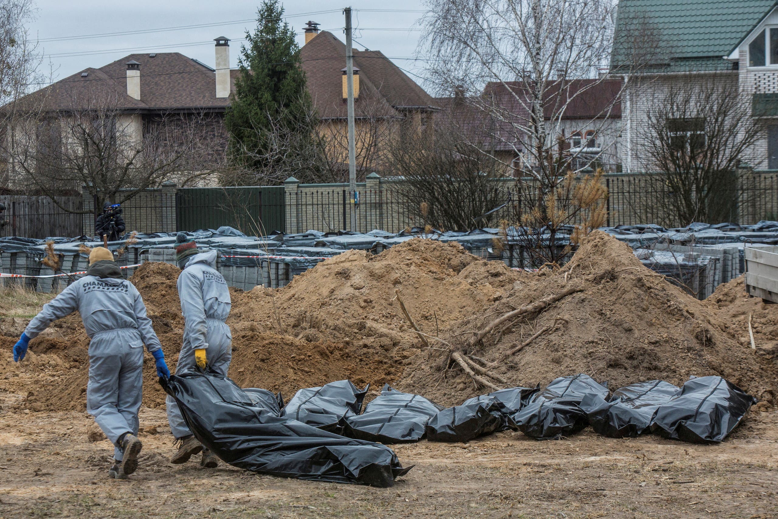 Forensic technicians carry pull the body of a civilian who Ukrainian officials say was killed during Russia’s invasion, then buried and exhumed from a mass grave in the town of Bucha, outside Kyiv, Ukraine April 13, 2022. (File Photo: Reuters)