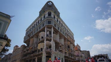 Emergency personnel stand in front of the Saratoga Hotel four days after it suffered an explosion in Havana, Cuba May 10, 2022. (Reuters)