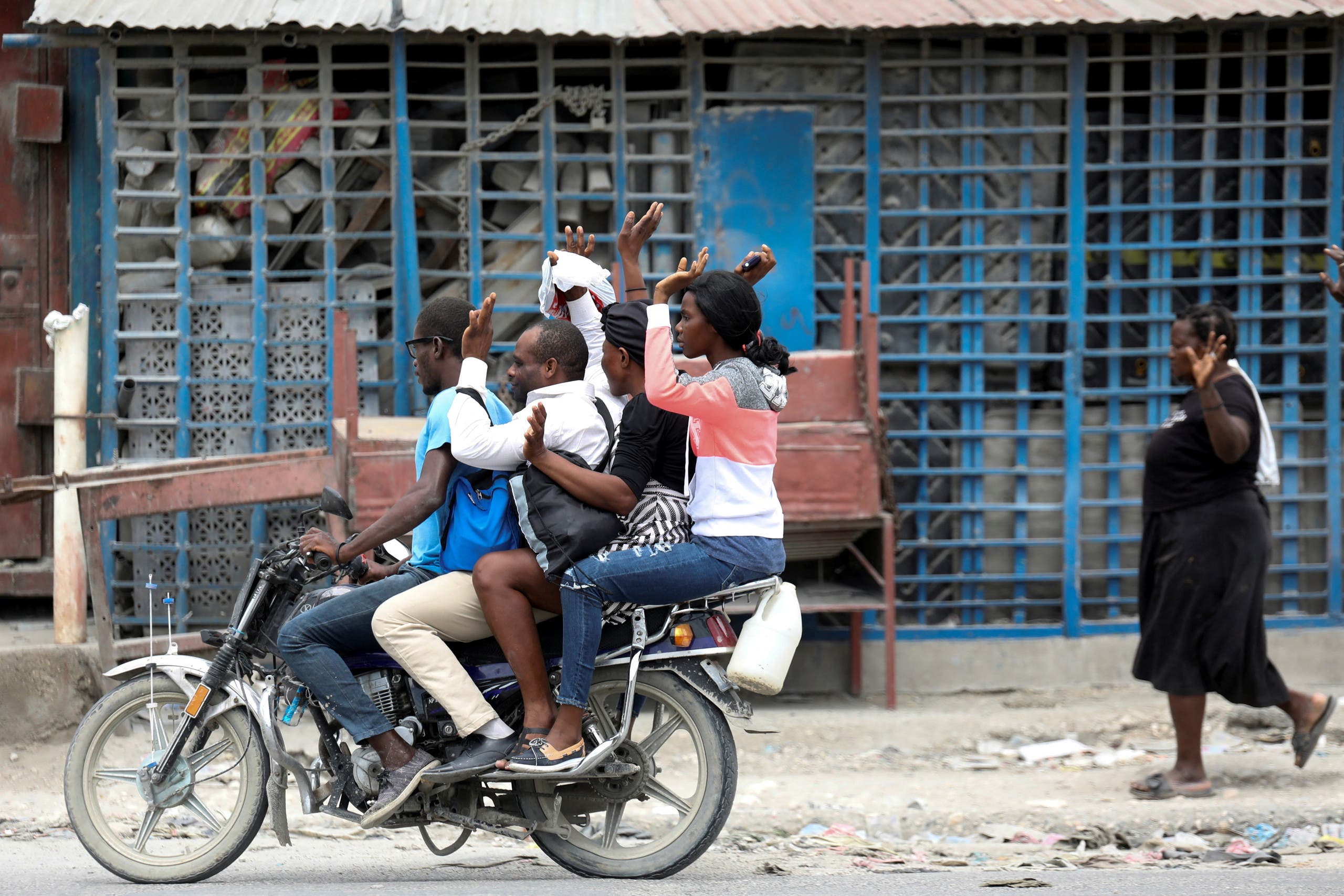 سكان من هايتي يفرون من منازلهم رافعين أيديهم بالهواء كي لا تستهدفهم العصابات