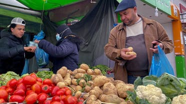 Lotfi Mansouri, a 55-year-old teacher, buys vegetables in Tunis, Tunisia, February 2, 2022. (Reuters)