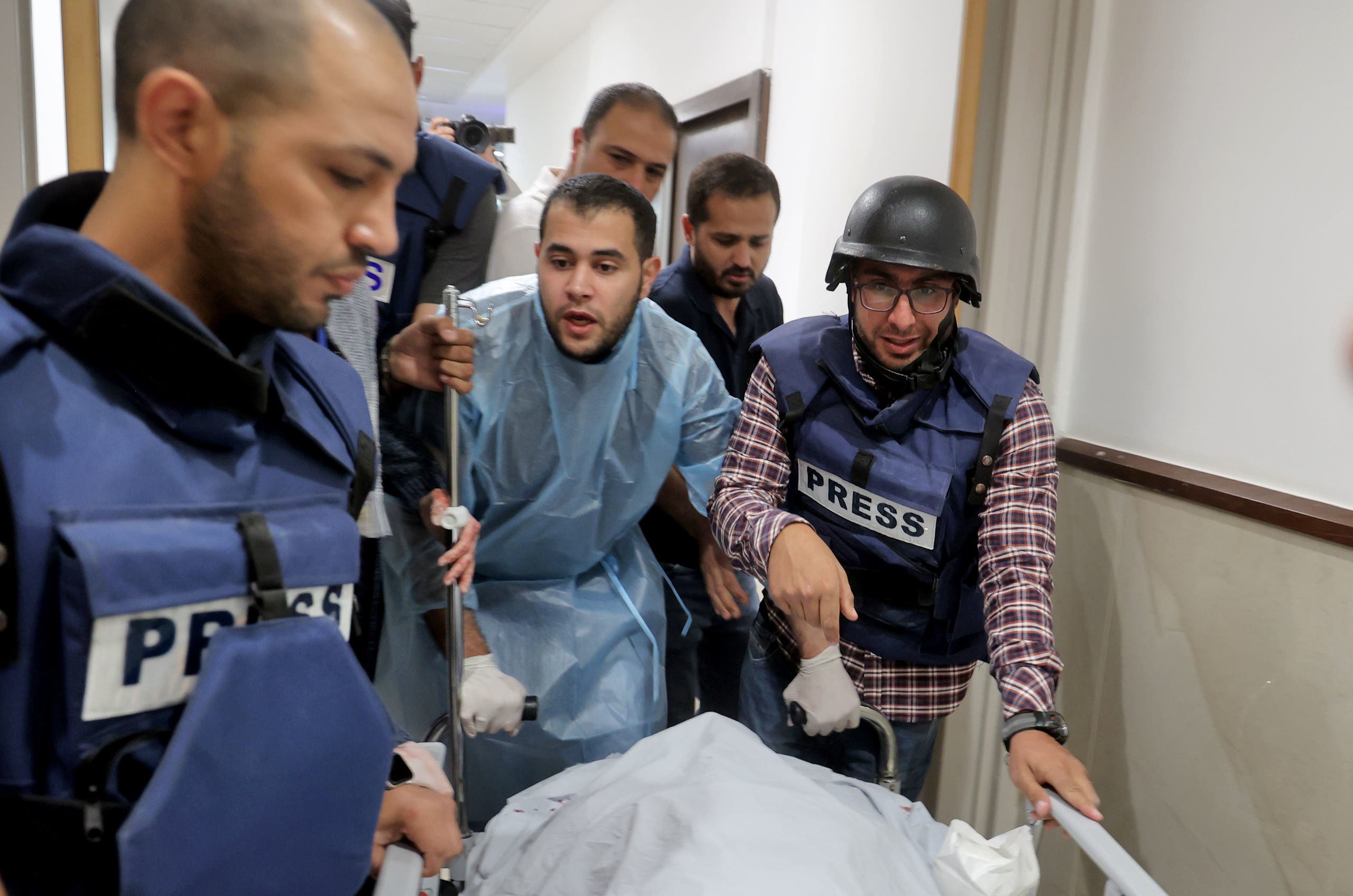 Journalists escort the body of veteran Al Jazeera journalist Shireen Abu Aqleh, who was shot dead by Israeli troops as she covered a raid on the West Bank's Jenin refugee camp on May 11, 2022, at the hospital in Jenin. (AFP)