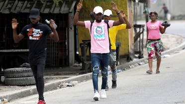 Residents raise their arms as they flee their homes due to ongoing gun battles between rival gangs, in Port-au-Prince, Haiti May 2, 2022. REUTERS/Ralph Tedy Erol