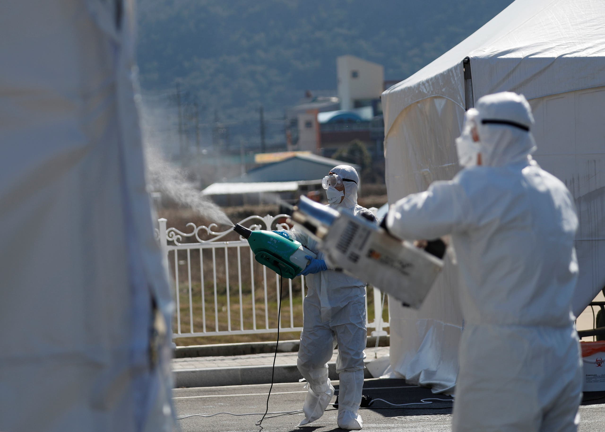 Quarantine workers in protective gear spray disinfectants at a screening facility for checking coronavirus disease (COVID-19) in Cheongdo county, which has been designated as a 'special care zone' since the coronavirus outbreak, near Daegu in North Gyeongsang Province, South Korea, March 11, 2020. (File photo: Reuters)