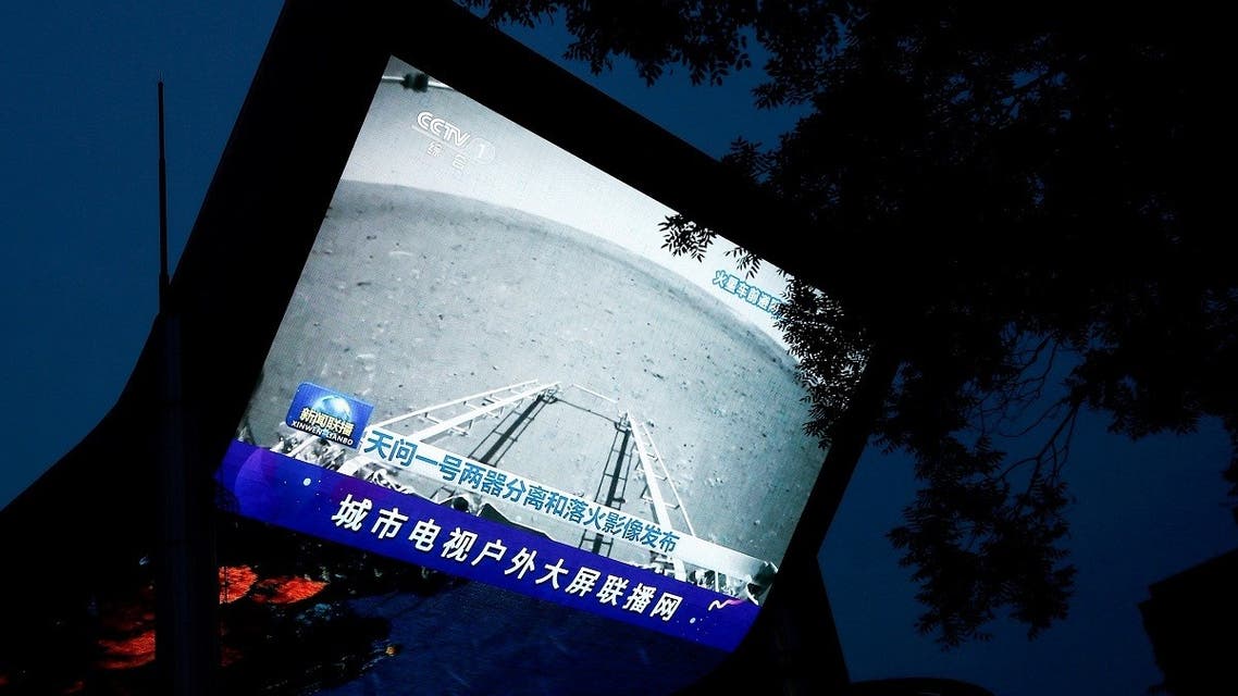 A screen broadcasts a CCTV state media news bulletin, showing an image of Mars taken by Chinese Mars rover Zhurong as part of the Tianwen-1 mission, in Beijing, China, on May 19, 2021. (Reuters)