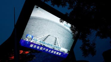 A screen broadcasts a CCTV state media news bulletin, showing an image of Mars taken by Chinese Mars rover Zhurong as part of the Tianwen-1 mission, in Beijing, China, on May 19, 2021. (Reuters)