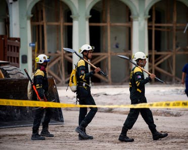 Members of the rescue brigade walk with their shovels as they work at the Saratoga Hotel days after a huge blast wrecked the building, in Havana, on May 11, 2022. The death toll from an explosion at the luxury hotel in the old quarter of Havana has risen to 43. Crews continued to comb through the rubble of the Saratoga five-star hotel, which was being renovated and had no guests at the time of the late-morning blast last Friday that was seemingly caused by a gas leak. (Photo by Yamil LAGE / AFP)