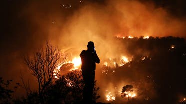 A man uses his mobile phone as wildfires burn a forest in Chbaniyeh village, Lebanon October 9, 2020. Picture taken October 9, 2020. (File photo: Reuters)