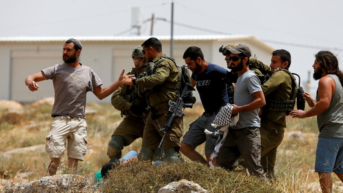 Israeli settlers scuffle with a Palestinian, on the ground, during a protest after Israeli top court paved way for razing eight Palestinian hamlets, in Masafer Yatta, south of Hebron, in the Israeli-occupied West Bank May 13, 2022. (File photo: Reuters)
