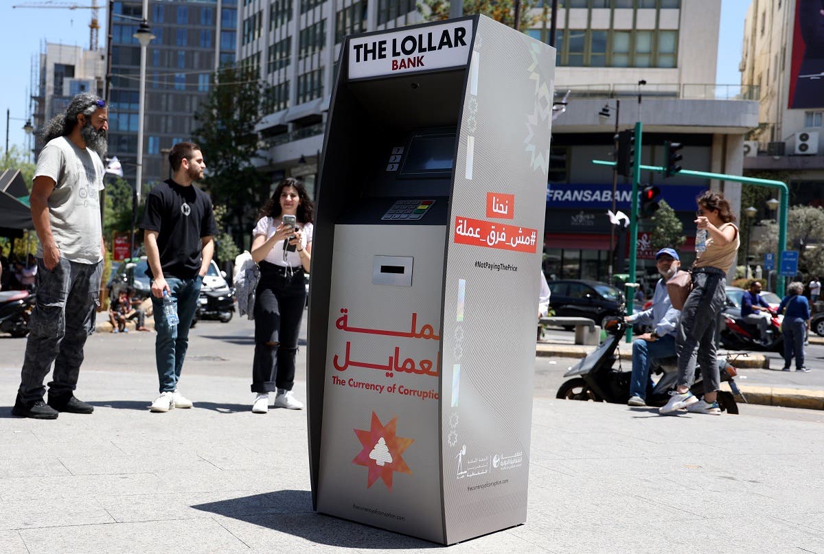 Lebanese surround a mock ATM, distributing fake banknotes called “Lollars,” during a stunt to denounce the high-level of corruption that has wrecked the country, in the capital Beirut, on May 13, 2022. (AFP)