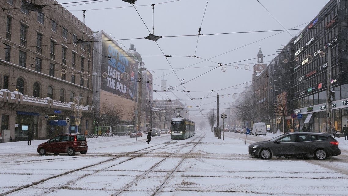 A photo taken on January 12, 2021 shows cars and a tramway driving in Mannerheimintie street in Helsinki, following snow fall. (AFP)