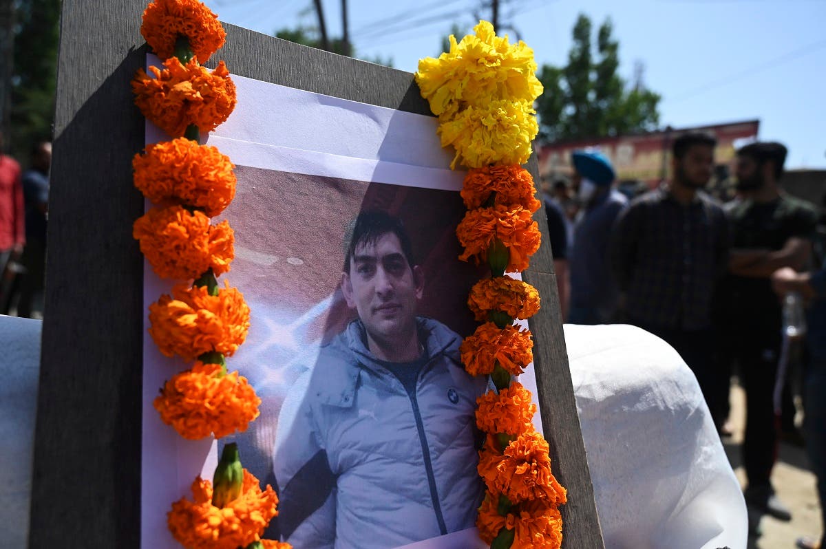 A placard with a photograph of slain Kashmiri pandit and government employee Rahul Bhat is seen during a protest against his killing on the outskirts of Srinagar on May 13, 2022. (AFP)