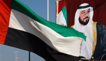 A United Arab Emirates flag waves in front of a big poster of President Sheikh Khalifa bin Zayed Al Nahyan in Abu Dhabi. December 15, 2009. (File photo: Reuters)