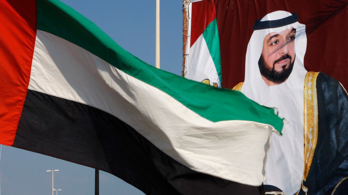 A United Arab Emirates flag waves in front of a big poster of President Sheikh Khalifa bin Zayed Al Nahyan in Abu Dhabi.  December 15, 2009. (File photo: Reuters)