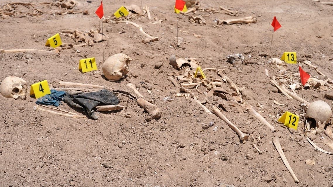 Human remains exhumed from a mass grave by Iraqi authorities, lie on the ground near the southern city of Najaf, on May 14, 2022. (AFP)
