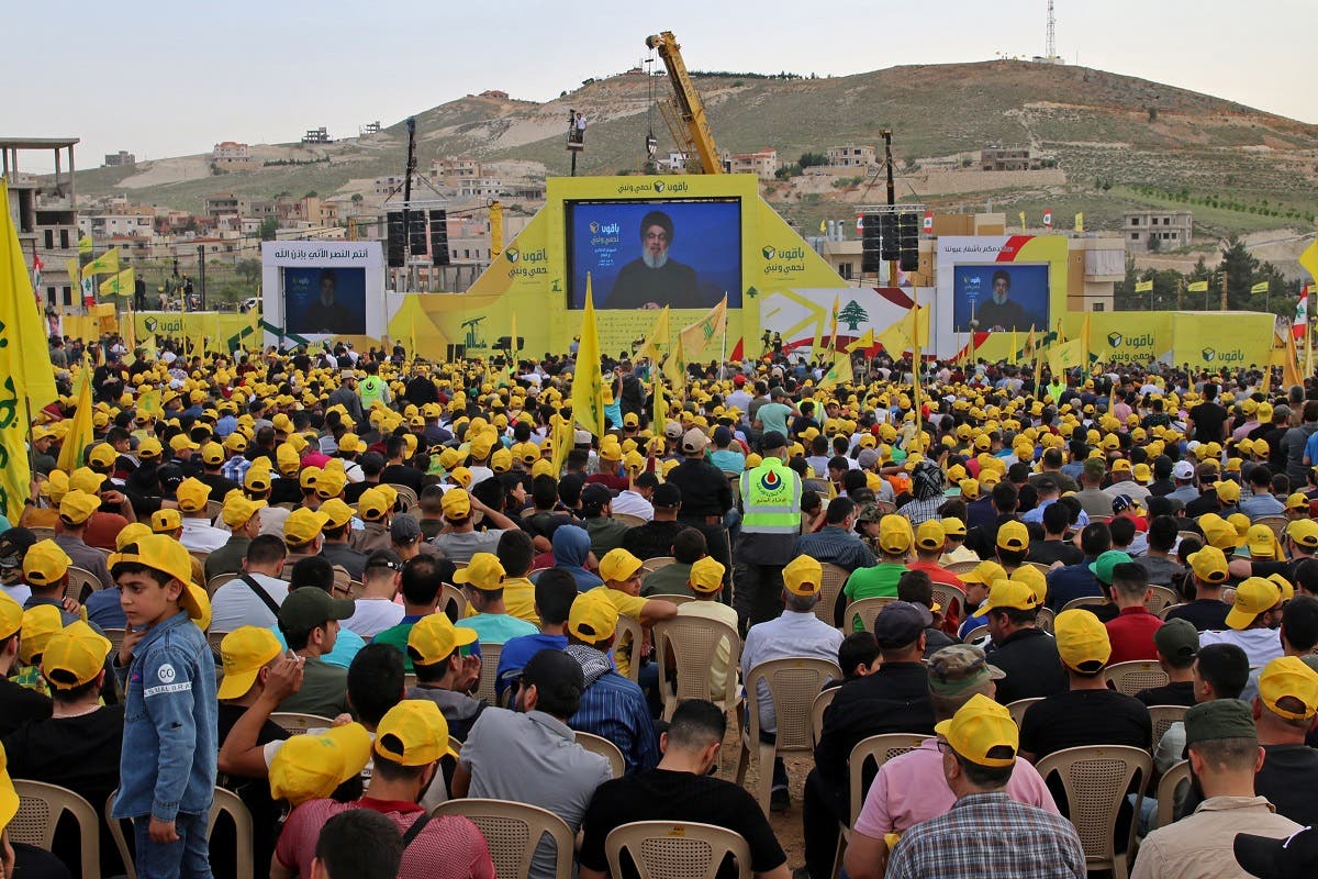A supporter of the Shia group Hezbollah watch a speech by the movement’s leader Hassan Nasrallah on a screen during a campaign rally in Baalbek in Lebanon’s eastern Bekaa Valley on May 13, 2022, ahead of the upcoming parliamentary elections on May 15. (AFP)
