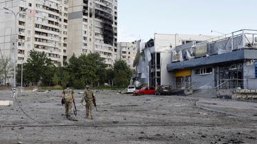 Ukrainian servicemen walk at a damaged area, as Russia's attack on Ukraine continues, in Kharkiv, Ukraine, May 14, 2022. (Reuters)