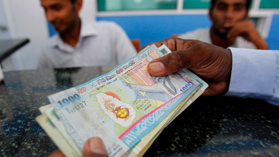A customer holds Sri Lankan rupee notes as he waits for more cash from a teller at a money exchange in Colombo May 5, 2010. (File photo: Reuters)