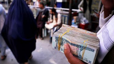 A person holds a bundle of Afghan afghani banknotes at a money exchange market in Kabul, Afghanistan, September 4, 2021. (File photo: Reuters)