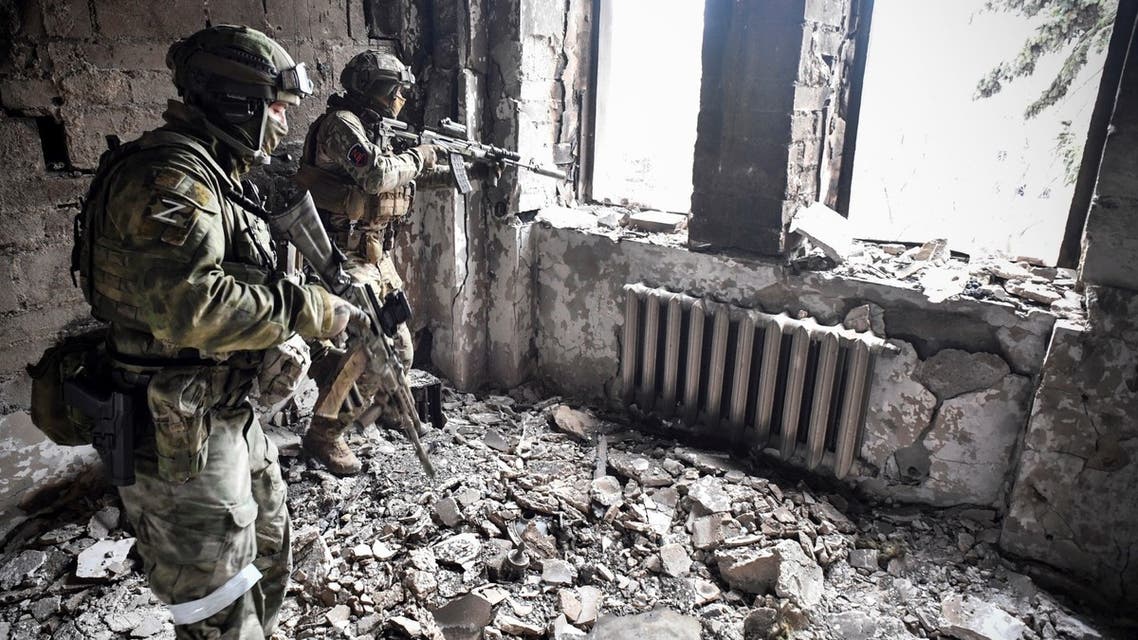 Two Russian soldiers patrol in the Mariupol drama theatre, bombed last March 16, in Mariupol on April 12, 2022. (AFP)