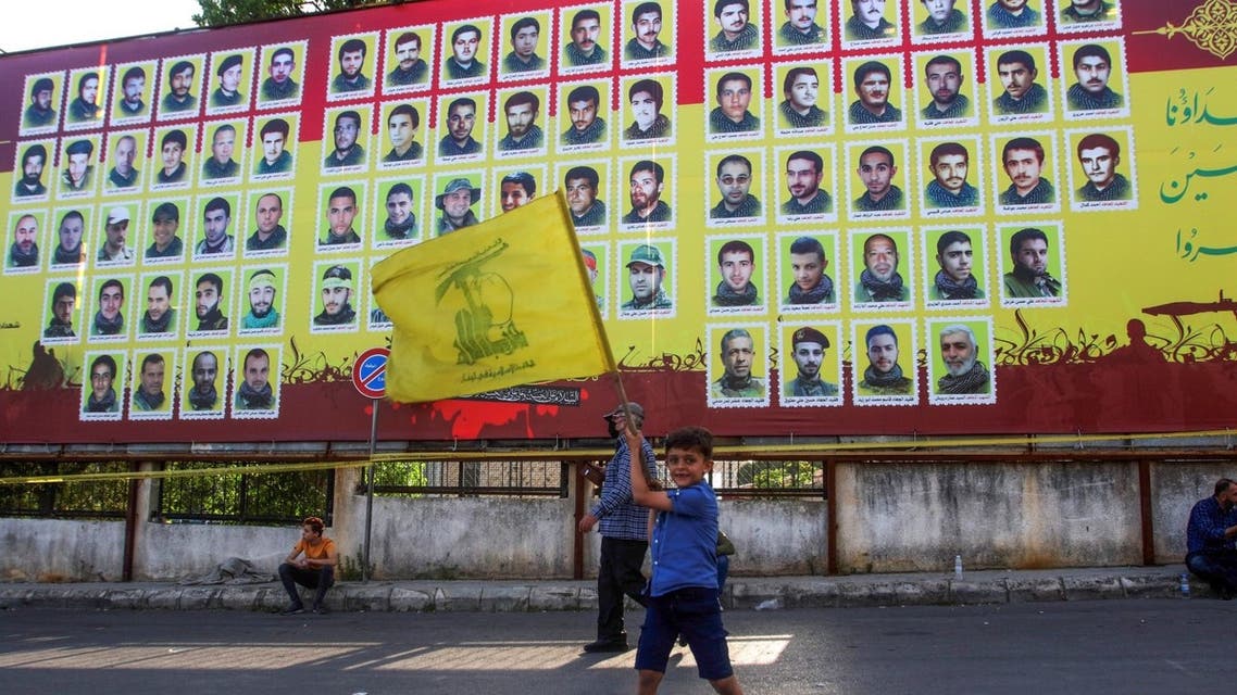 A boy waves a flag Lebanon's Iran-backed Shiite group Hezbollah during a rally to attend a speech by Hezbollah leader Hassan Nasrallah, broadcast on a giant screen, in the southern city of Nabatiyeh, on May 9, 2022, ahead of the upcoming parliamentary elections on May 15. (AFP)
