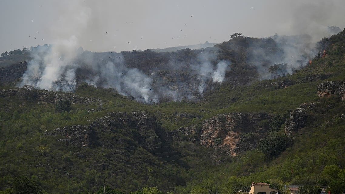 Smoke rises from a fire, which erupted on Margalla Hills due to rising temperatures on a hot summer day near Saidpur village in Islamabad on May 28, 2021. (AFP)