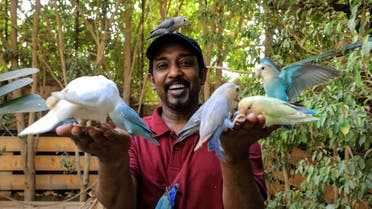 An undated handout photo obtained on May 14, 2022, from Khartoum's Marshall Nature Reserve for exotic birds, shows the owner of the facility Akram Yehia with some of the protected birds in the capital Khartoum. Tucked away east of Sudan's capital Khartoum, a sanctuary of lush green vegetation has been a haven for dozens of exotic birds from far and wide. (Photo by Khartoum Marshall Nature Reserve / AFP) / RESTRICTED TO EDITORIAL USE - MANDATORY CREDIT AFP PHOTO / KHARTOUM MARSHALL NATURE RESERVE - NO MARKETING NO ADVERTISING CAMPAIGNS - DISTRIBUTED AS A SERVICE TO CLIENTS - RESTRICTED TO EDITORIAL USE - MANDATORY CREDIT AFP PHOTO / Khartoum Marshall Nature Reserve - NO MARKETING NO ADVERTISING CAMPAIGNS - DISTRIBUTED AS A SERVICE TO CLIENTS