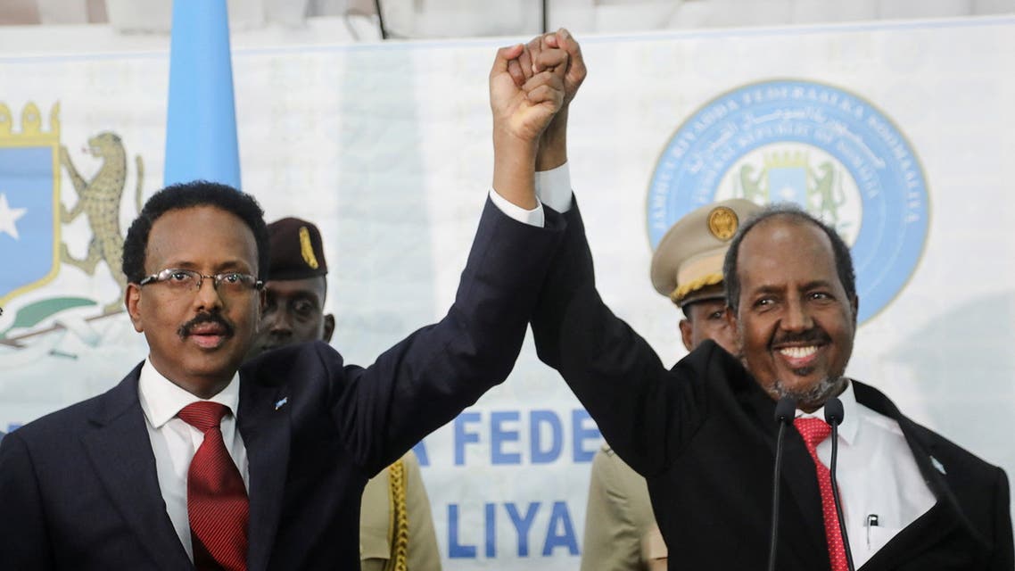 Somalia's newly elected president Hassan Sheikh Mohamud holds hands with incumbent president Mohamed Abdullahi Mohamed after winning the elections in Mogadishu, Somalia May 16, 2022. (Reuters)