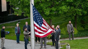 Employees rise up the flag outside the US embassy in Kyiv on May 18, 2022, as the embassy reopens after closing it for three months due to the Russian invasion. (AFP)