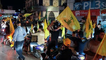 Supporters of Lebanon's Hezbollah and Amal Movement carry flags in southern Lebanon on May 15, 2022. (Reuters)